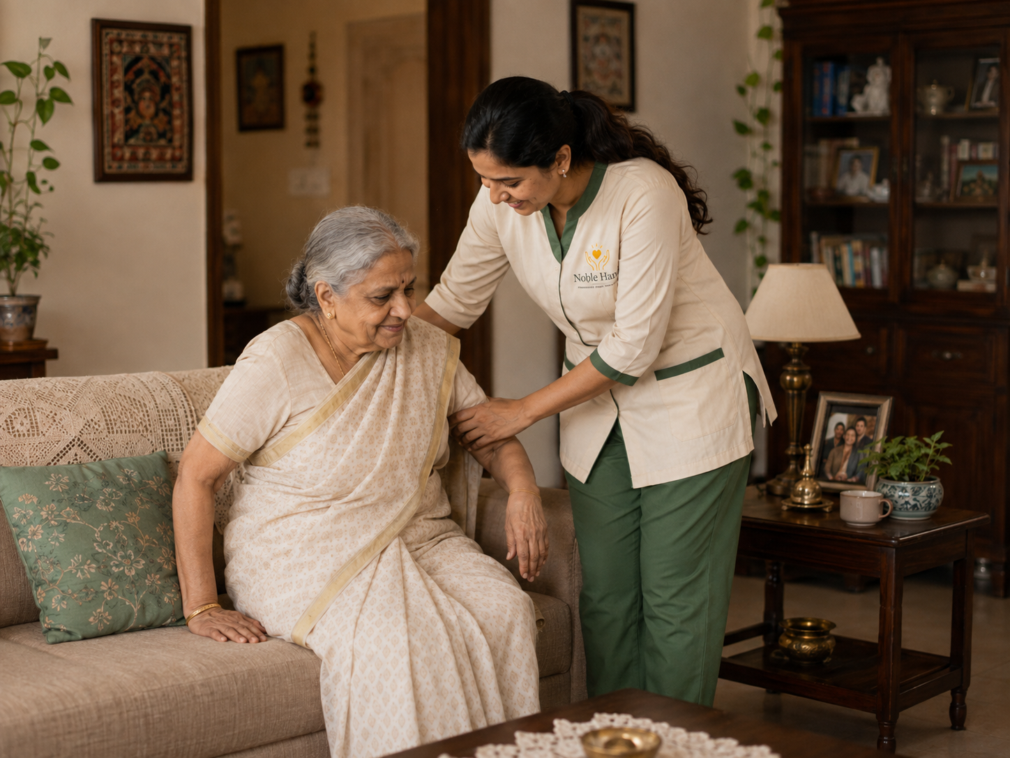 A caregiver helps an older woman stand safely from her sofa at home.